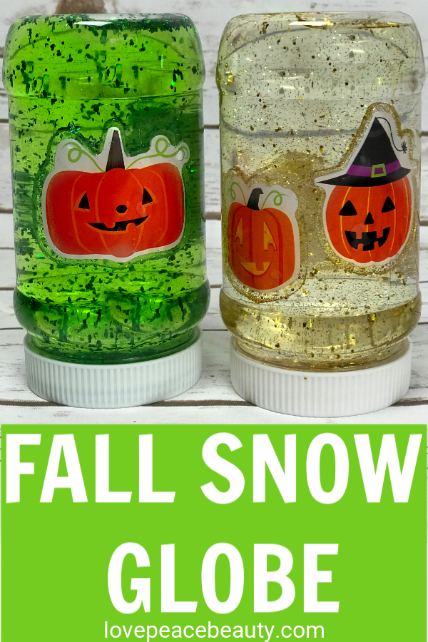 DIY snow globe in a plastic jar with gold glitter and pumpkin faces inside the jar. A fall activity for kids