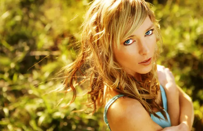 A woman with side-swept bangs posing outside