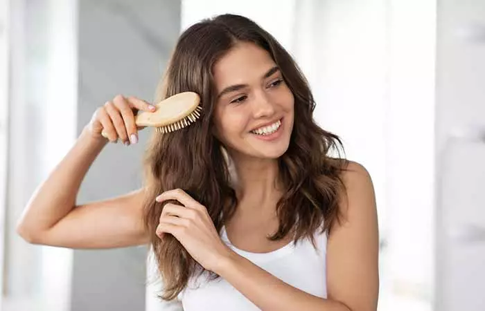 woman detangling her hair 