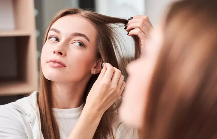 A woman checking her hair in the mirror