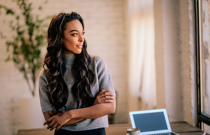 A black woman with a wavy curl quick weave hairstyle